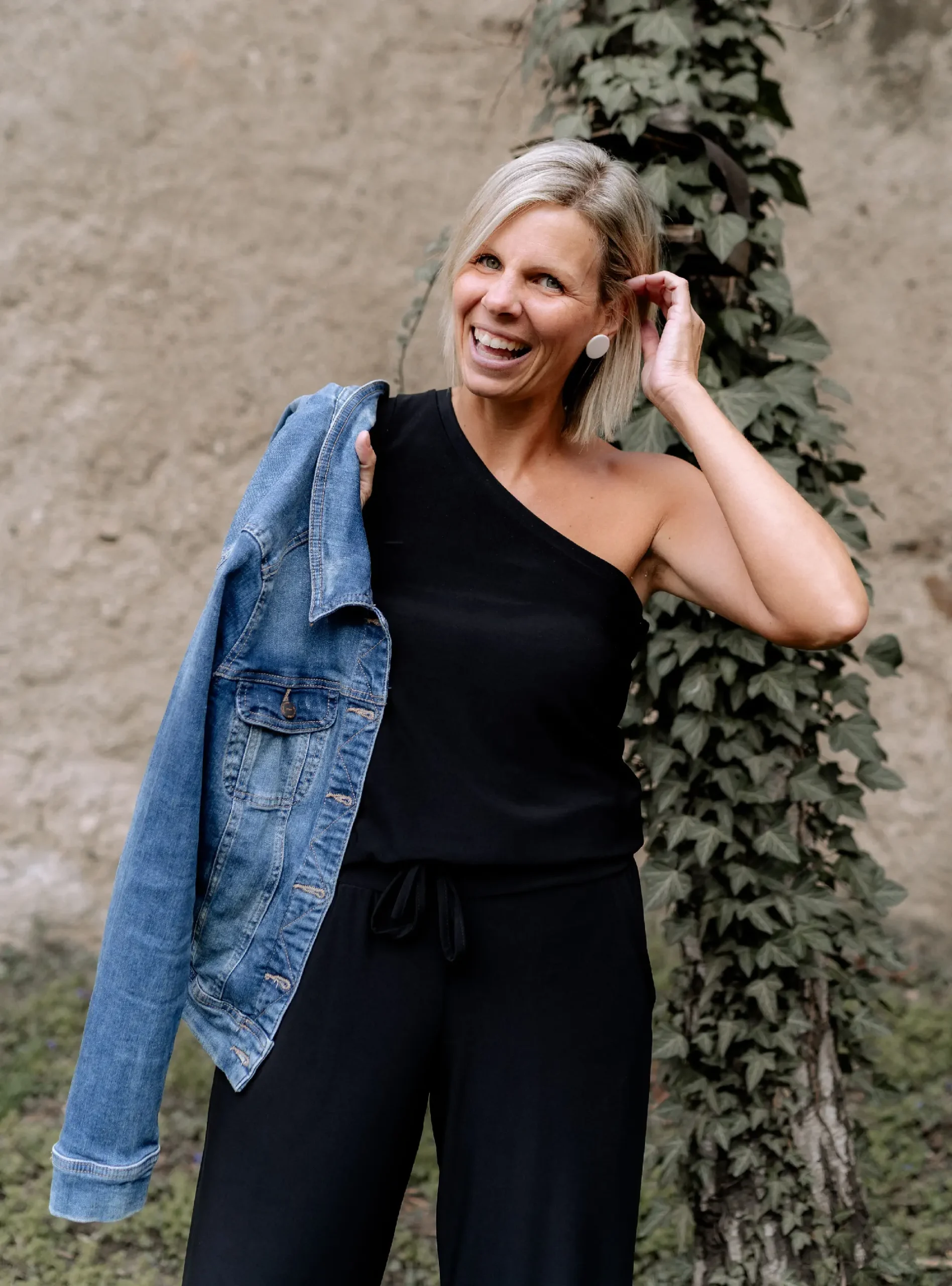 Andra Löffler, ganz in schwarz gekleidet mit einer Jeansjacke um die Schulter